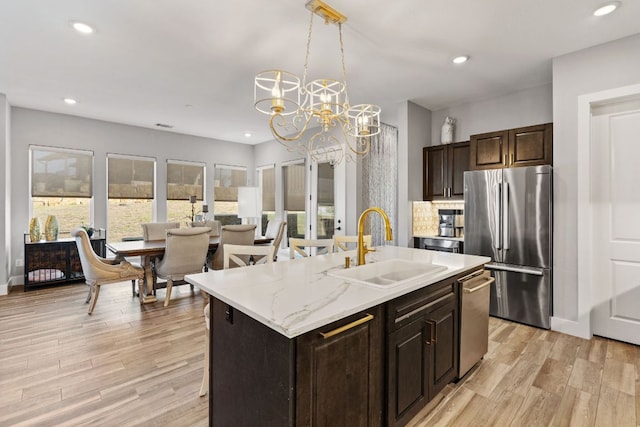 kitchen with recessed lighting, appliances with stainless steel finishes, light wood-style floors, and a sink