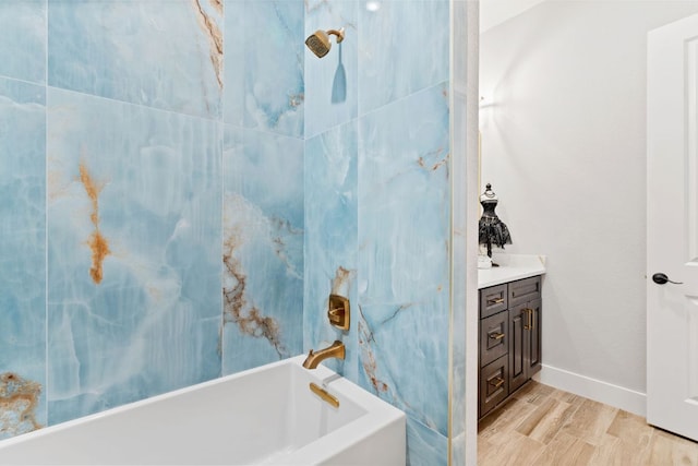 full bath with baseboards, wood finished floors, a bath, vanity, and a shower