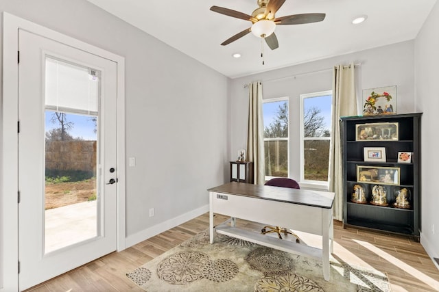 home office with light wood finished floors, recessed lighting, a ceiling fan, and baseboards