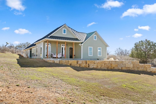 view of front of home featuring a standing seam roof, a front lawn, covered porch, and metal roof