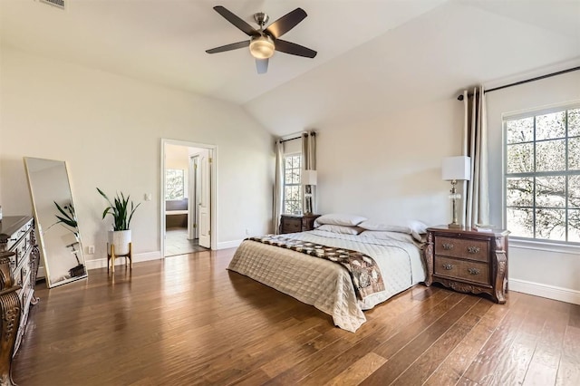 bedroom with vaulted ceiling, multiple windows, and wood finished floors