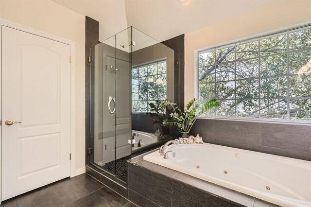 full bath with tile patterned floors, a tub with jets, and a stall shower