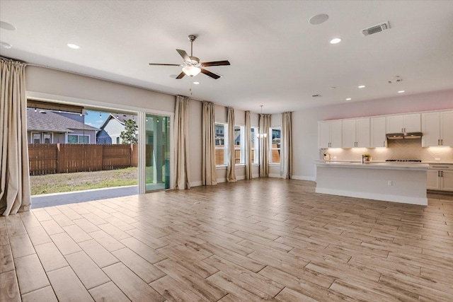 unfurnished living room featuring baseboards, visible vents, recessed lighting, ceiling fan, and light wood-style floors