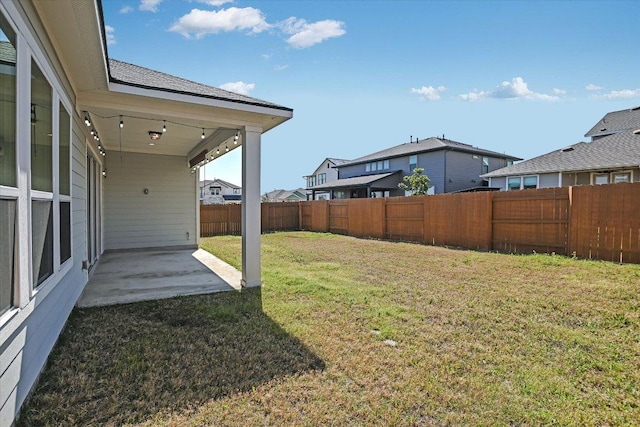 view of yard featuring a residential view, a patio, and fence