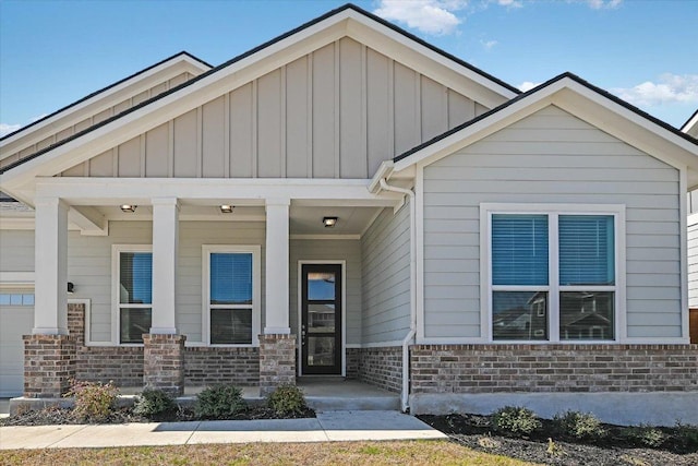 view of front of property featuring a porch, brick siding, and board and batten siding