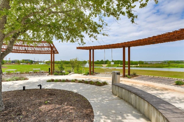 view of property's community featuring a yard, a water view, and a pergola