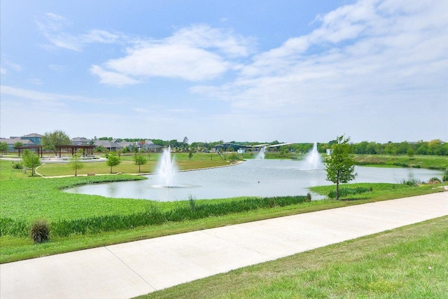 view of home's community featuring a lawn and a water view