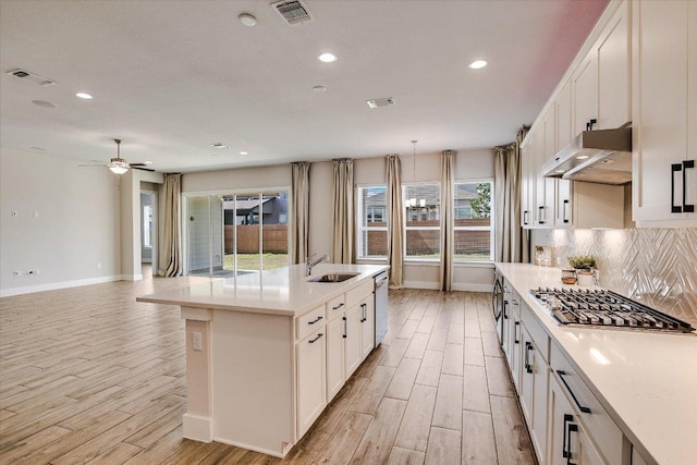 kitchen featuring visible vents, stainless steel gas stovetop, under cabinet range hood, dishwasher, and backsplash