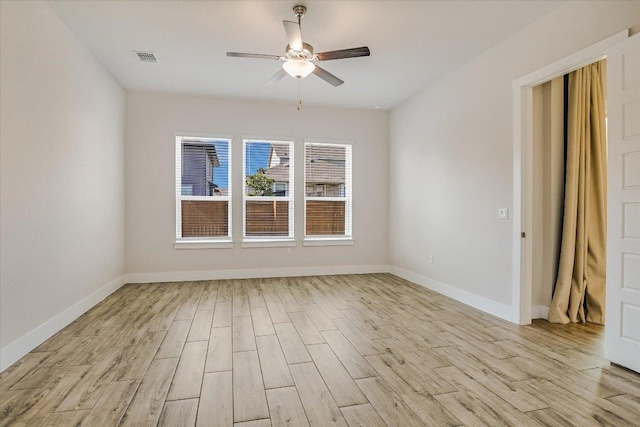 unfurnished room with light wood-style flooring, visible vents, baseboards, and ceiling fan