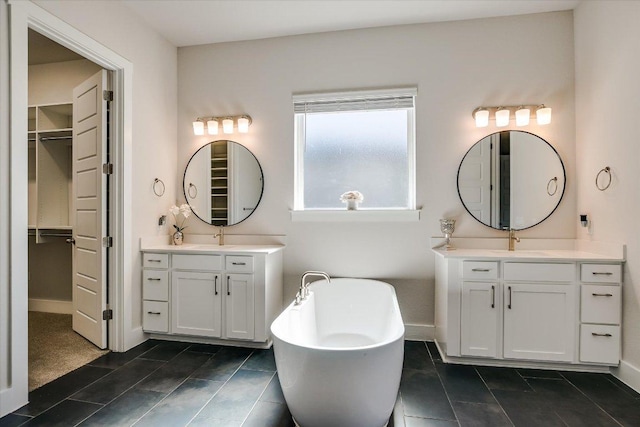 full bath with a soaking tub, two vanities, baseboards, and a sink