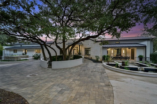 view of front of property with a standing seam roof, a patio area, and metal roof