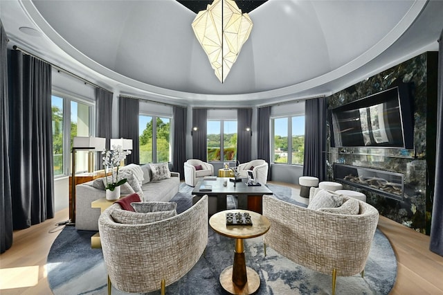 living room featuring a premium fireplace, wood finished floors, and vaulted ceiling