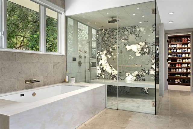 full bathroom with a shower stall, a garden tub, tile walls, and recessed lighting