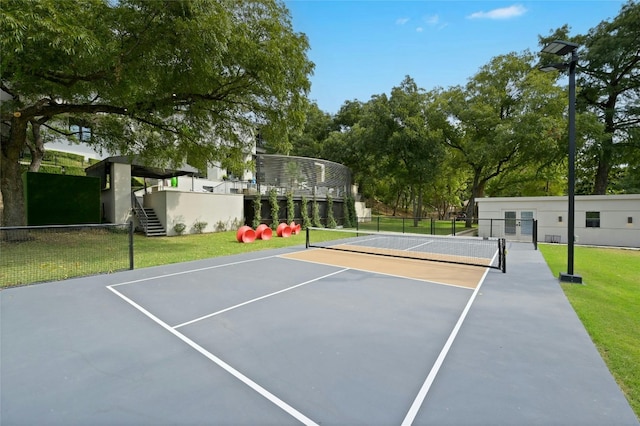 view of sport court featuring fence and a lawn