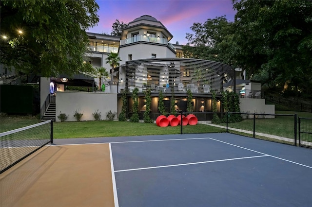 view of basketball court with community basketball court, fence, and a lawn