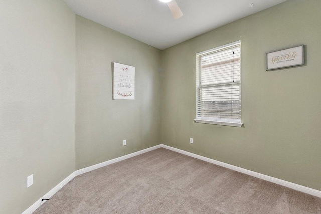 carpeted empty room with baseboards and ceiling fan