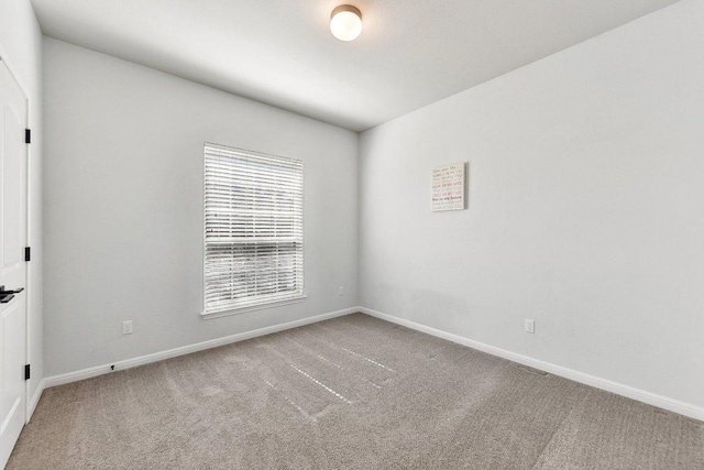 carpeted spare room with baseboards