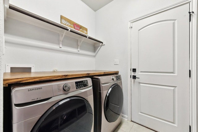 washroom featuring light tile patterned floors, laundry area, and washer and clothes dryer