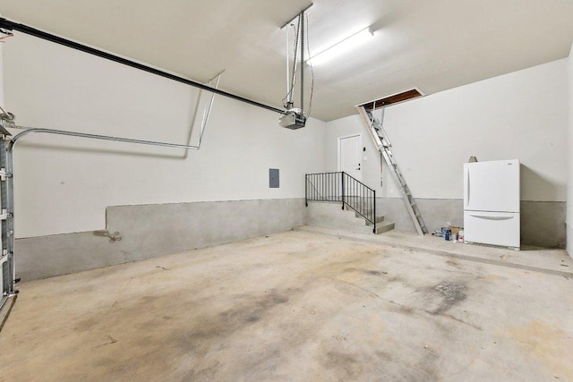 garage featuring a garage door opener and freestanding refrigerator