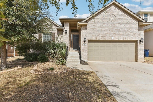 view of front of house with brick siding, driveway, and a garage