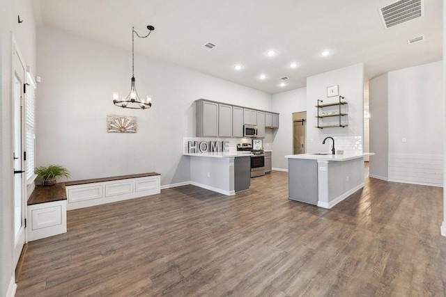 kitchen featuring a sink, visible vents, appliances with stainless steel finishes, and a peninsula