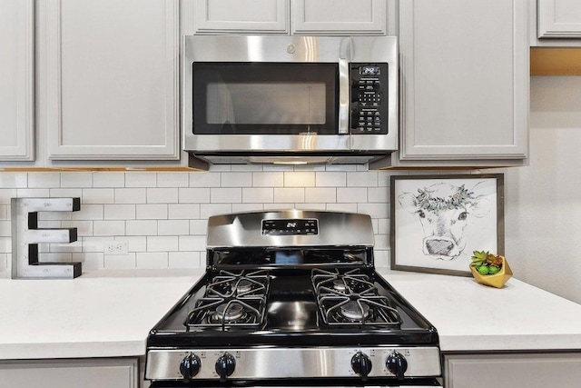 kitchen featuring decorative backsplash, appliances with stainless steel finishes, and light countertops