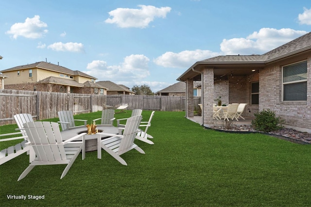 view of yard with a fenced backyard, an outdoor fire pit, and a patio