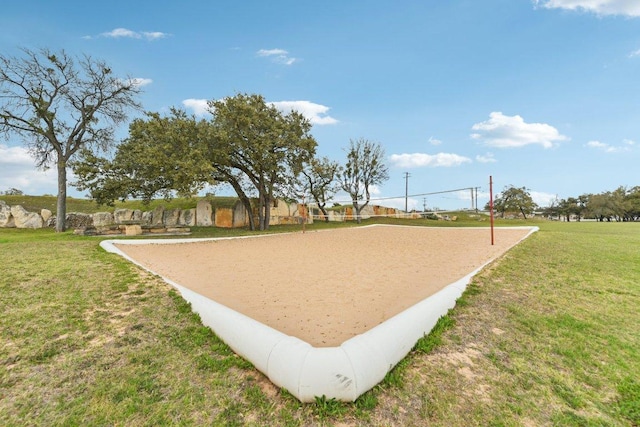 view of community with a lawn and volleyball court