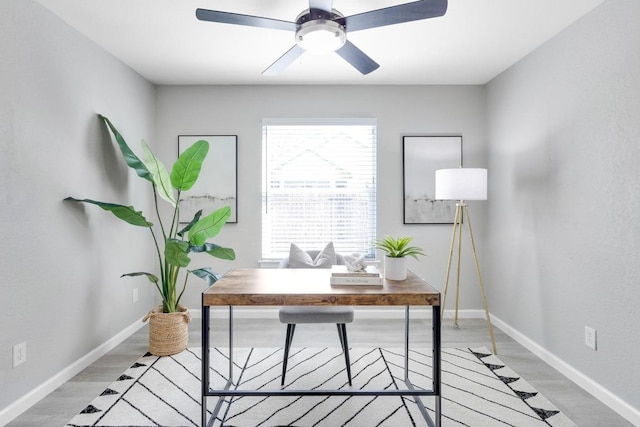 home office with a ceiling fan, light wood-style floors, and baseboards