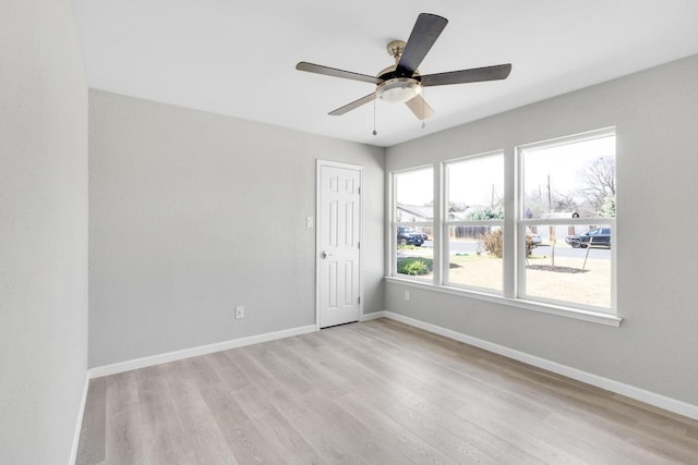 empty room featuring ceiling fan, baseboards, and light wood-type flooring