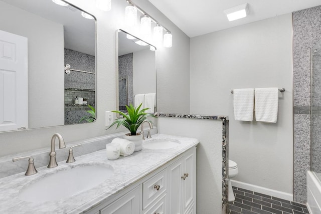 bathroom with double vanity, toilet, a shower, and a sink