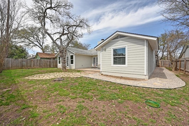 back of property featuring a yard, a patio area, and a fenced backyard