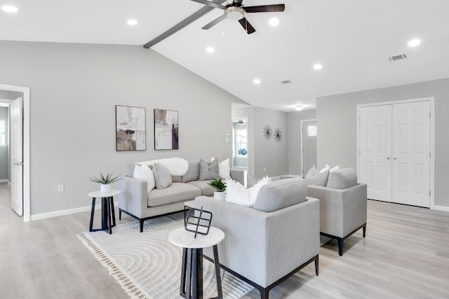 living room with a ceiling fan, visible vents, light wood finished floors, baseboards, and lofted ceiling with beams