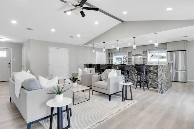 living area featuring visible vents, light wood-style flooring, recessed lighting, lofted ceiling, and ceiling fan