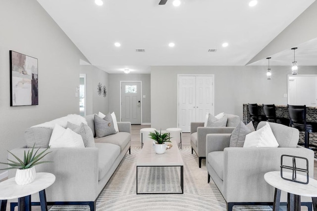 living room with recessed lighting, light wood finished floors, and vaulted ceiling