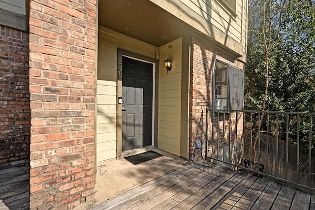 view of exterior entry featuring brick siding