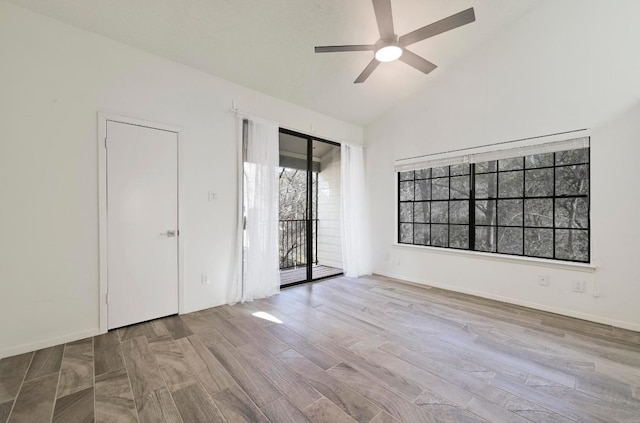 empty room featuring high vaulted ceiling, baseboards, a ceiling fan, and wood finished floors