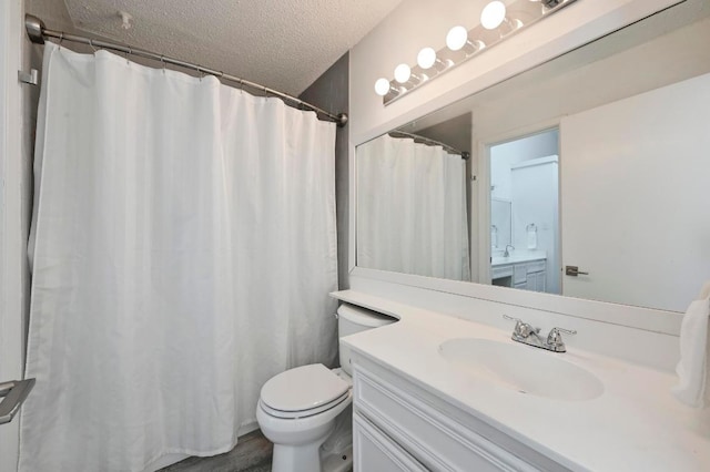 bathroom with vanity, a shower with shower curtain, toilet, and a textured ceiling