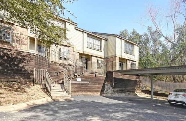 multi unit property featuring stairs and covered parking