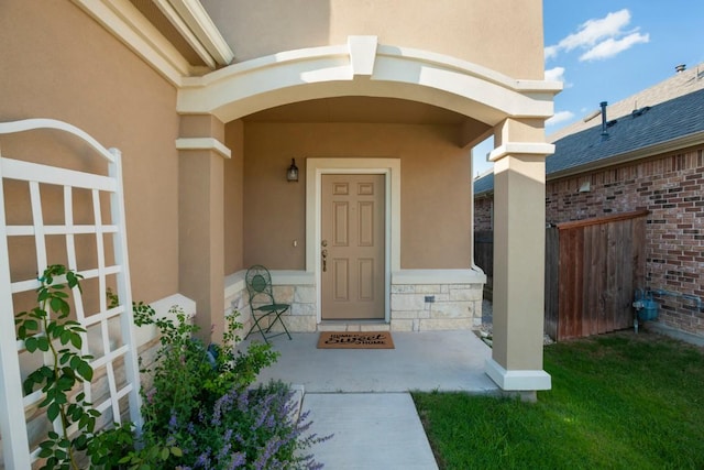 doorway to property with stone siding and stucco siding