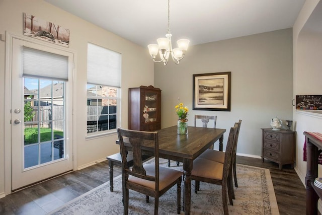 dining space featuring a notable chandelier, dark wood-style floors, and baseboards