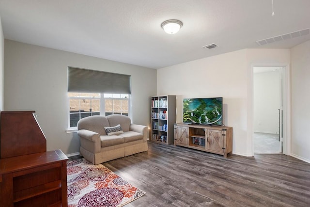 living area with visible vents, baseboards, and wood finished floors