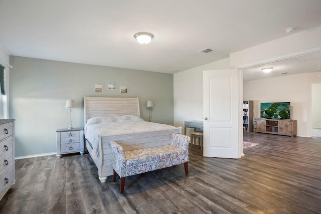 bedroom with wood finished floors, visible vents, and baseboards