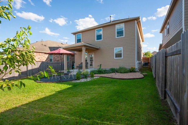 back of house featuring a patio, a lawn, and a fenced backyard