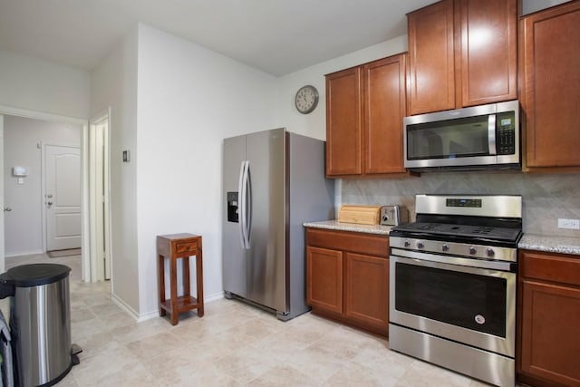 kitchen with brown cabinets, baseboards, tasteful backsplash, and stainless steel appliances