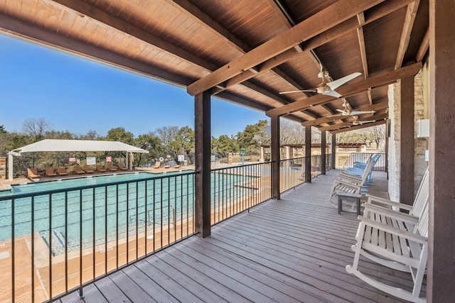 deck featuring a community pool and ceiling fan