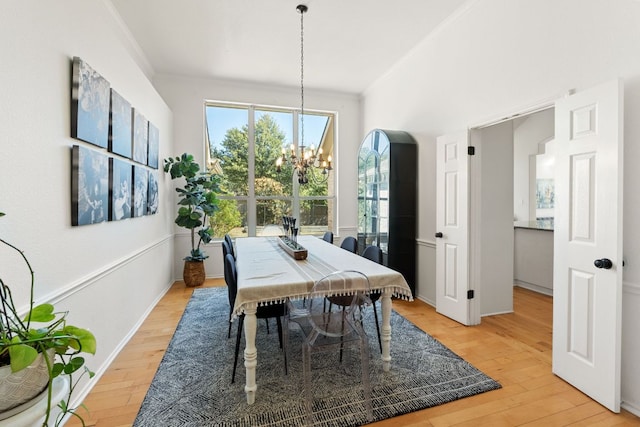 dining space with an inviting chandelier, crown molding, and light wood finished floors