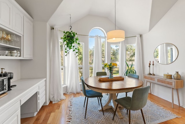 dining room featuring vaulted ceiling and light wood finished floors