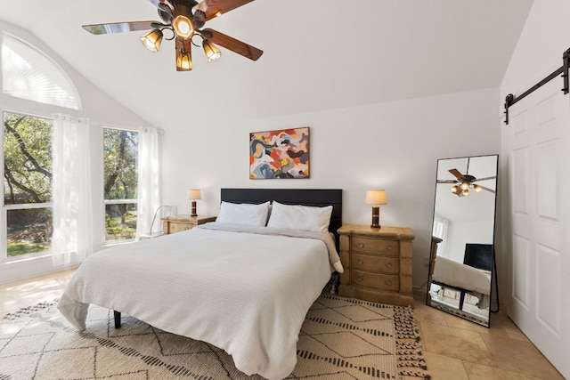 bedroom featuring a ceiling fan, lofted ceiling, and a barn door