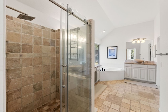 bathroom with a shower stall, stone tile flooring, vaulted ceiling, a bath, and vanity